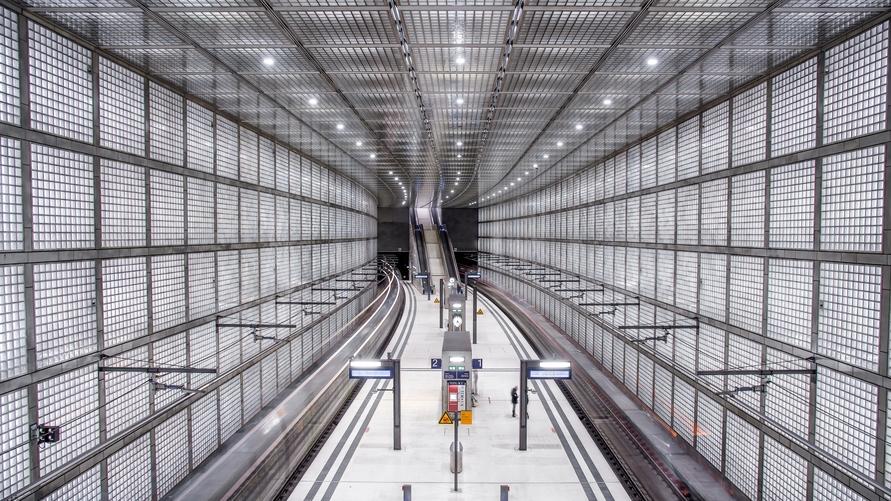 Blick auf den fertigen Bahnsteig des City-Tunnels Leipzig mit Glasbaustein-Wänden und architektonisch markantem Lichtkonzept.