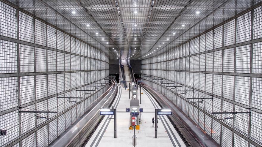View of the completed platform at City Tunnel Leipzig featuring glass brick walls and a distinctive architectural lighting design.