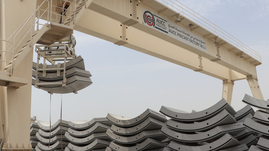 Gestapelte Tübbinge aus Stahlfaserbeton und Portalkran bei AUCC – bereit für den Einbau im Wakrah & Wukair Drainage Tunnel in Katar.