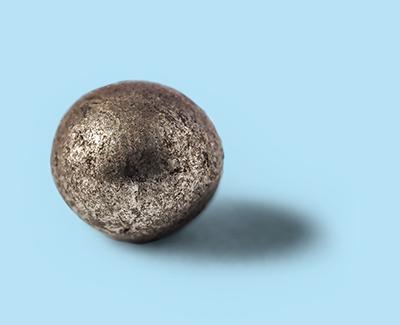 Einzelnes Blastex® CS Stahl-Drahtkorn auf blauem Hintergrund – für effiziente und langlebige industrielle Strahlprozesse.